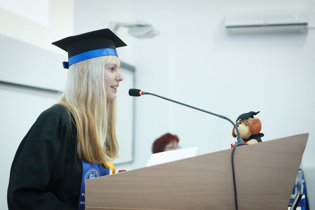 Graduate speaking at a commencement podium